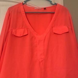Orange dolman top with 2 foe front pockets.
